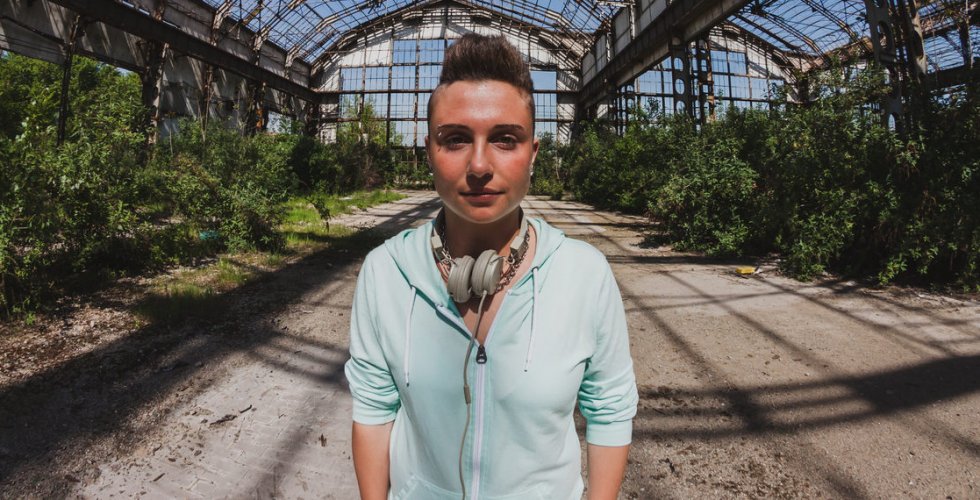 Fisheye portrait of short hair person with hoodie posing in an abandoned factory