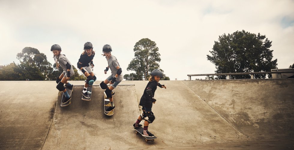 Shot of a group of young children skateboarding together at a skatepark