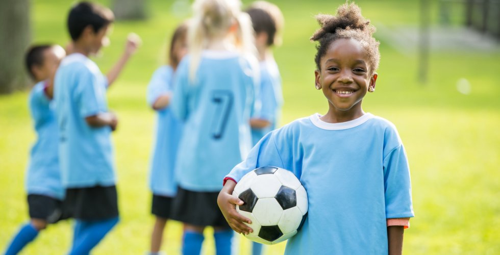 Little kids playing soccer outside